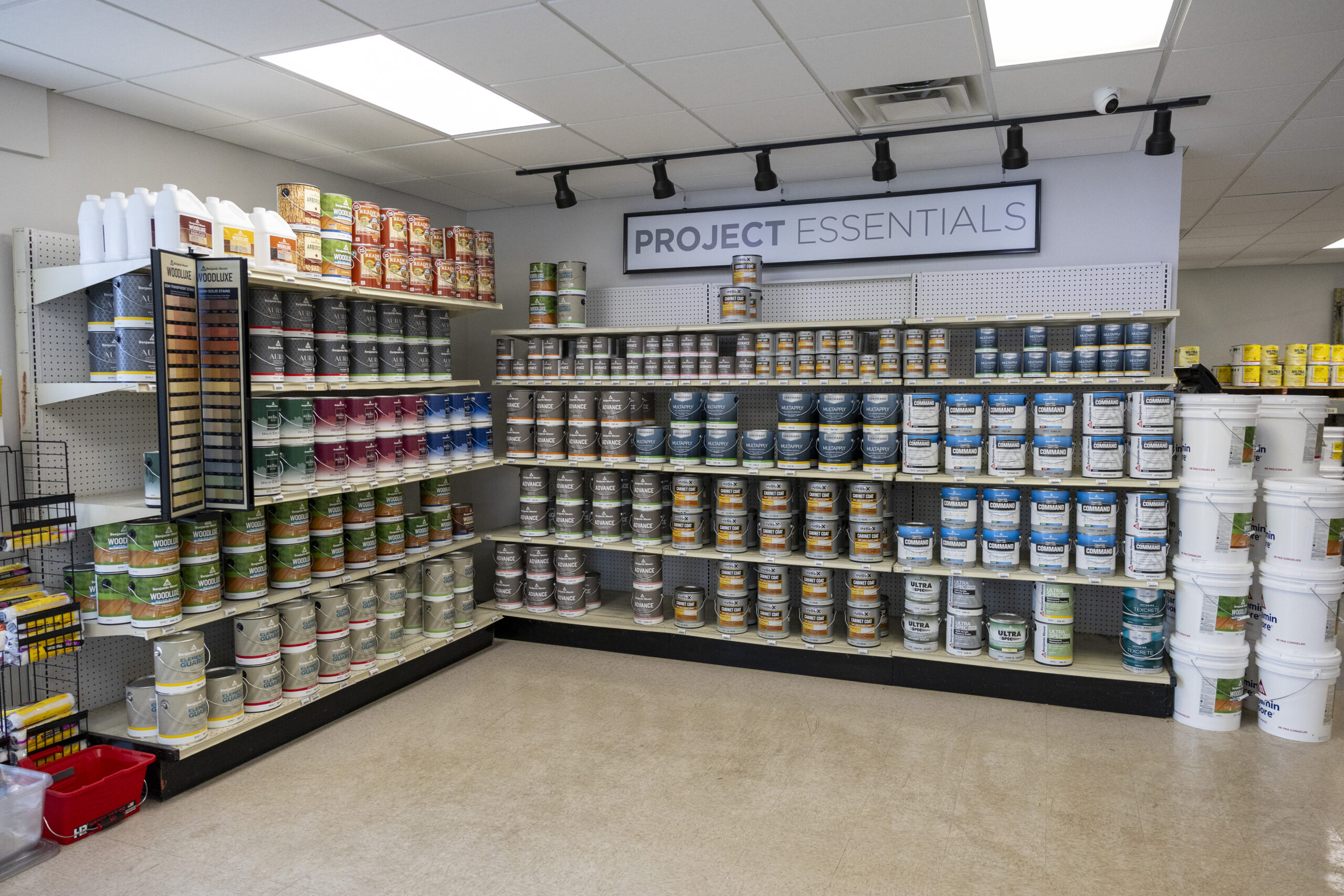 wall of shelves filled with Benjamin Moore paint cans and essentials for projects